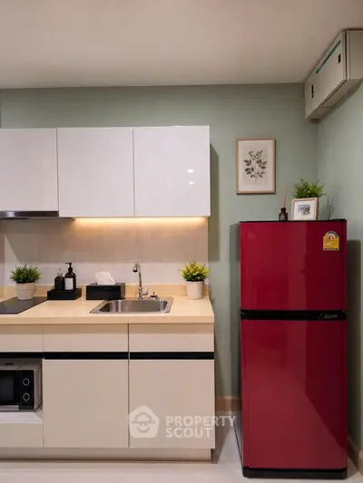 Modern kitchen with sleek cabinets and vibrant red fridge