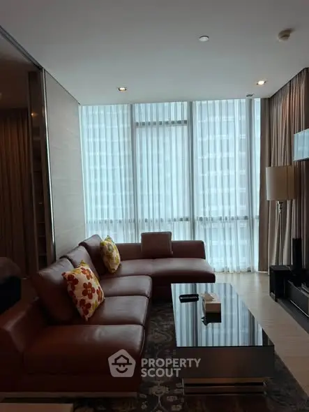 Luxurious living room with modern leather sofa and floor-to-ceiling windows in high-rise apartment.
