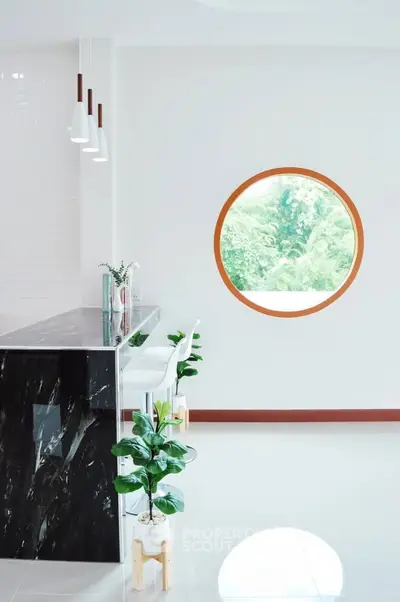 Modern kitchen with sleek black marble counter and round window view