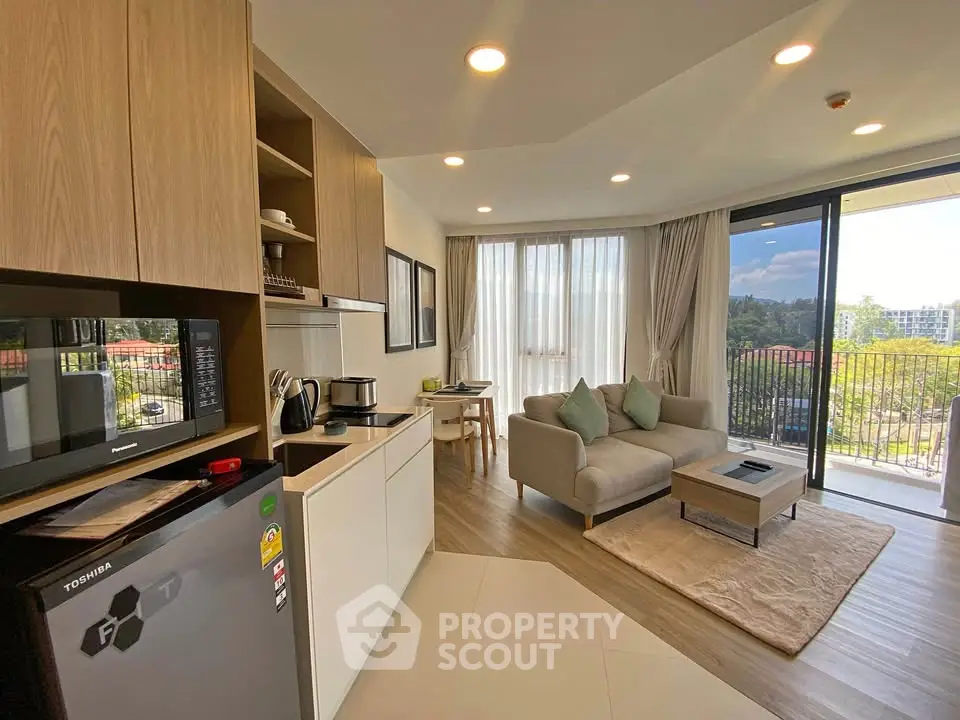 Modern open-layout living room with kitchen and balcony view in a stylish apartment.