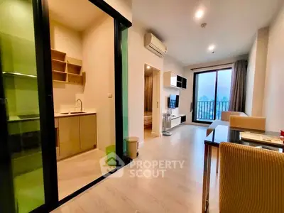 Modern apartment interior with open living room and kitchen, featuring sleek design and balcony view.