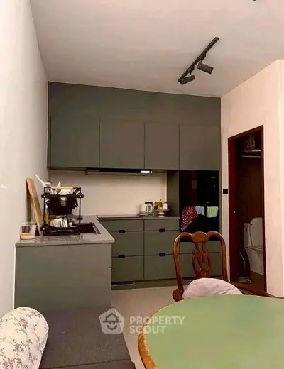 Modern kitchen with sleek cabinetry and dining area, featuring a cozy atmosphere.