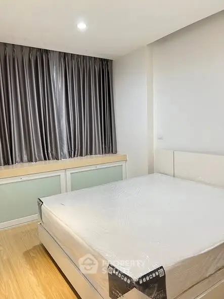 Spacious bedroom with large window and modern decor