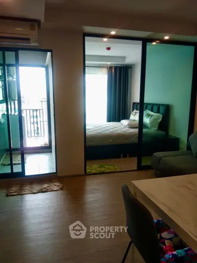 Modern apartment interior with glass partition, cozy bedroom, and stylish living area.