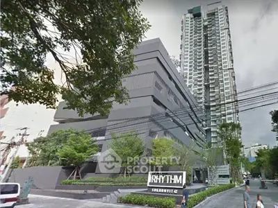 Modern high-rise building with lush greenery at Rhythm Sukhumvit 42, offering urban living in Bangkok.