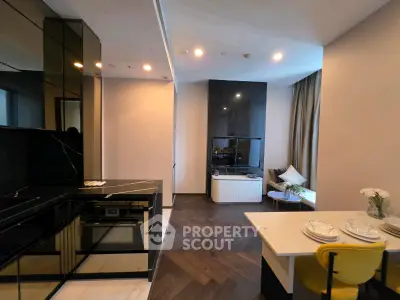 Modern open-layout kitchen and living room with sleek black finishes and cozy dining area.