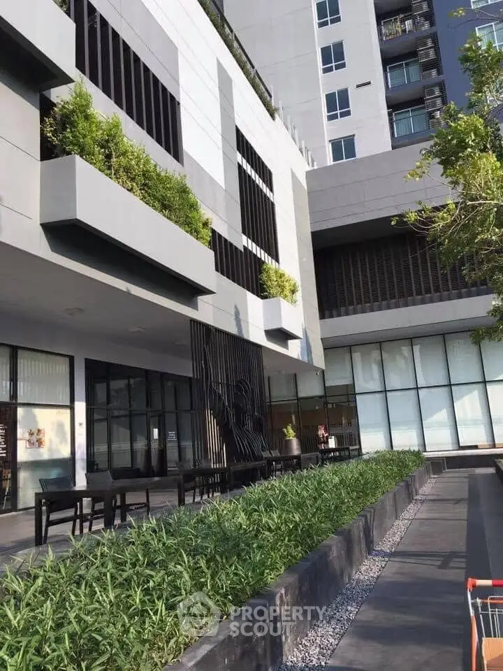 Modern apartment building exterior with lush greenery and stylish facade design.