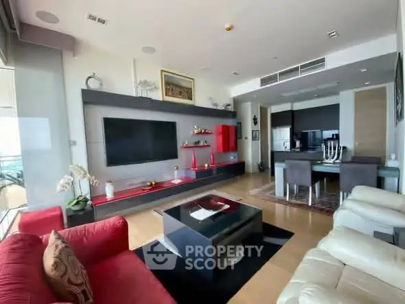 Luxurious modern living room with open kitchen, featuring sleek furniture and stylish decor.