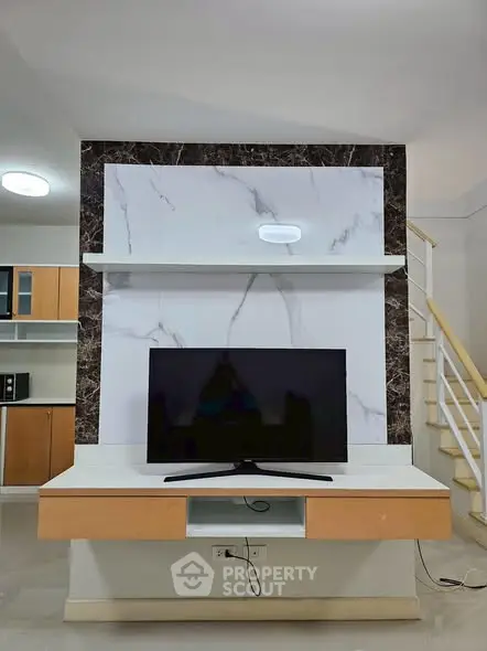 Modern living room with stylish TV setup and elegant marble accents