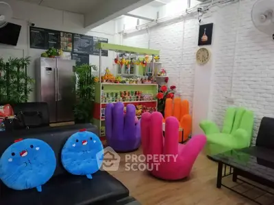Vibrant and quirky living room with colorful hand-shaped chairs and modern decor.