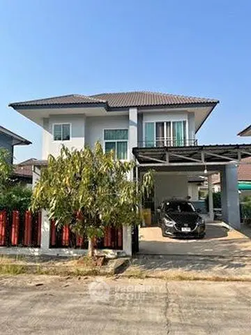 Charming two-story house with carport and lush garden in a serene neighborhood.