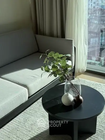 Modern living room with sleek sofa and stylish coffee table in natural light.