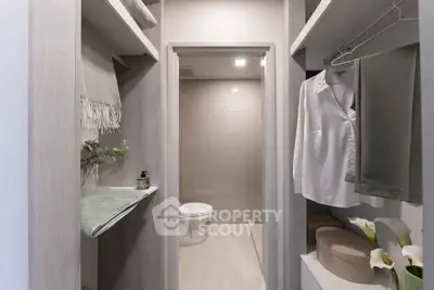 Modern bathroom with elegant decor and neutral tones, featuring a sleek toilet and stylish shelving.