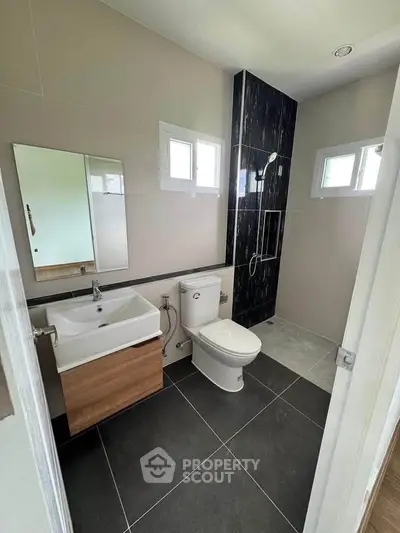 Modern bathroom with sleek fixtures and stylish black accent wall