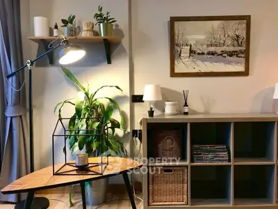 Cozy living room with stylish decor, featuring a wooden table, indoor plants, and a scenic wall painting.
