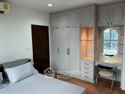 Spacious bedroom with built-in wardrobe and city view, perfect for urban living.