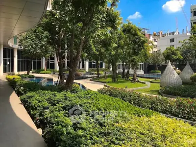Luxurious garden view of modern residential complex with lush greenery and serene pathways.