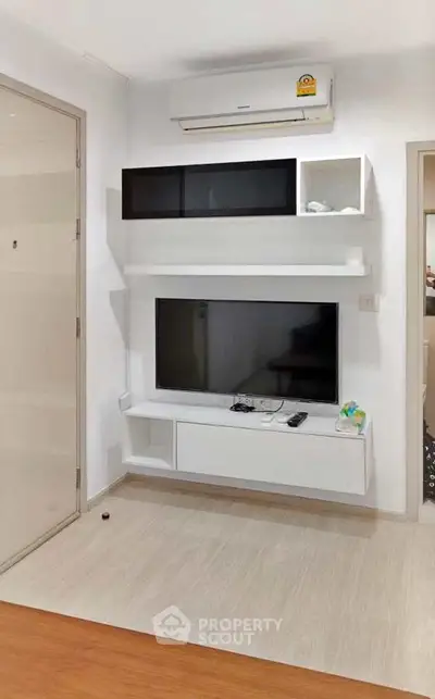 Modern living room with sleek TV unit and air conditioning, perfect for cozy entertainment.