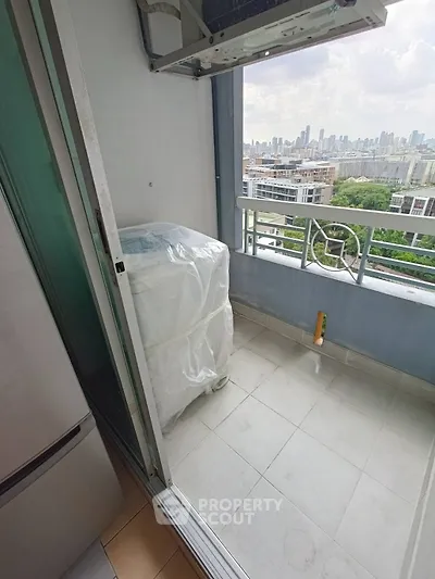 High-rise balcony with city skyline view and washing machine setup.