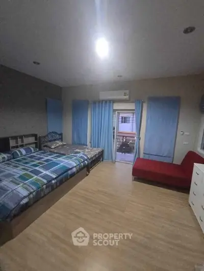 Spacious bedroom with modern decor and balcony access, featuring a cozy bed and stylish furnishings.