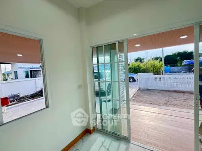 Bright interior with sliding glass doors opening to a spacious patio and garden view.