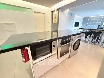 Modern kitchen with sleek appliances and stylish breakfast bar in contemporary home.