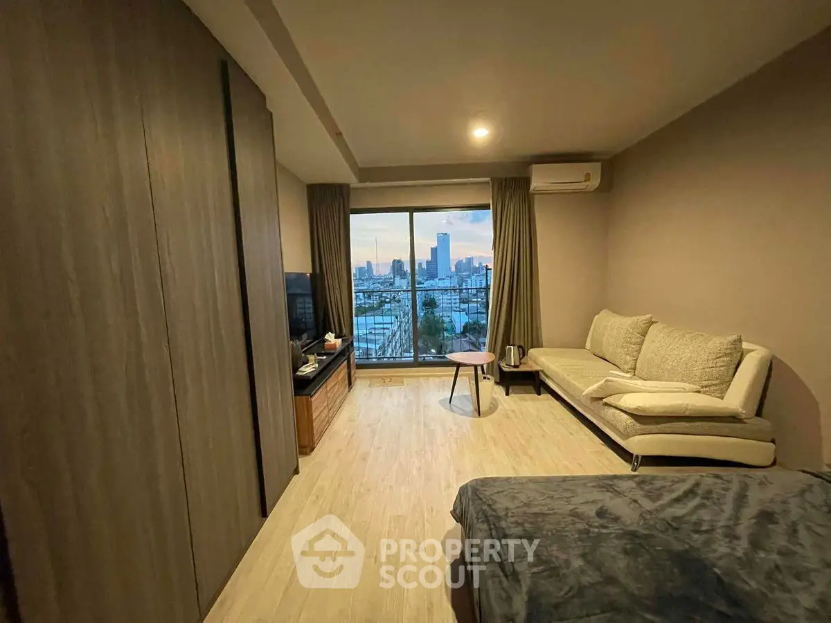 Modern living room with city view, cozy sofa, and stylish decor