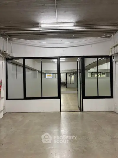 Spacious commercial space with glass partitions and polished concrete floors, ideal for office or retail use.