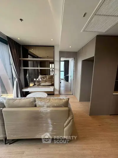 Modern living room with stylish furniture and floor-to-ceiling windows in a luxury apartment.