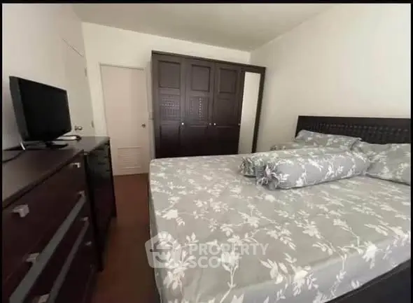 Spacious bedroom with elegant wooden furniture and floral bedding