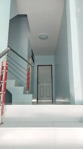 Modern interior staircase with sleek railing and white door in a minimalist home design.