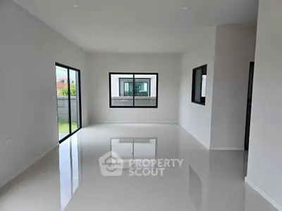 Spacious modern living room with large windows and glossy floors