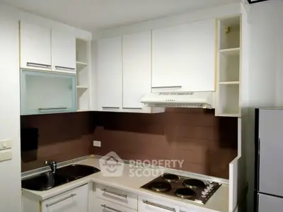 Modern kitchen with sleek cabinetry and electric stove in a compact layout.