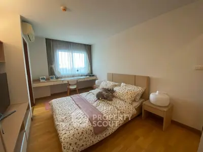 Cozy bedroom with stylish decor and natural light, featuring a comfortable bed and functional workspace.