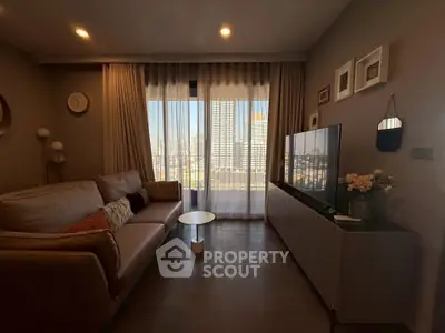 Modern living room with cozy sofa, large TV, and city view through floor-to-ceiling windows.