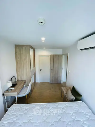 Modern bedroom with minimalist design, featuring a comfortable bed, stylish desk, and ample storage space.