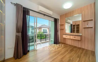 Spacious bedroom with wooden flooring and balcony access in modern home