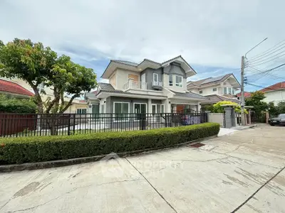 Charming two-story house with lush greenery and modern architecture in a serene neighborhood.
