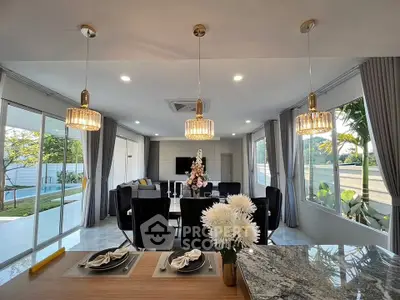 Luxurious open-plan living room with elegant decor and large windows overlooking a serene garden.