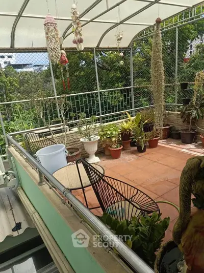 Charming balcony garden with lush greenery and cozy seating, perfect for relaxation and enjoying nature.