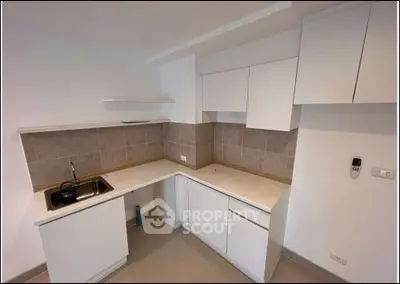 Modern kitchen with sleek white cabinets and tiled backsplash