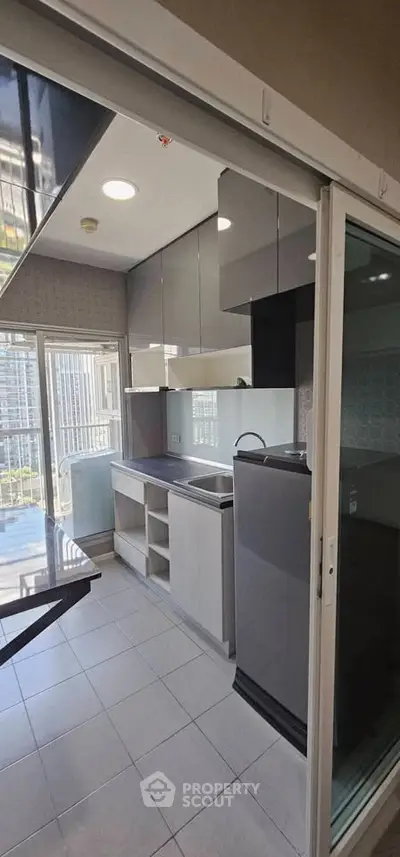 Modern kitchen with sleek cabinets and large windows offering natural light and city views.