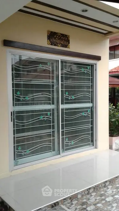 Charming exterior view of a house with decorative sliding glass doors and tiled entrance.