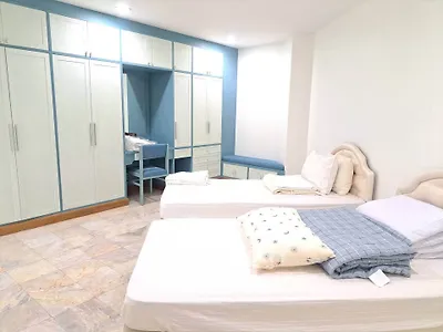 Spacious bedroom with twin beds and ample closet space in modern apartment.