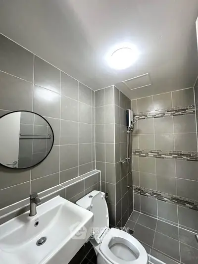 Modern bathroom with sleek gray tiles and round mirror