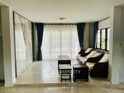 Spacious living room with elegant marble accents and large windows for natural light.