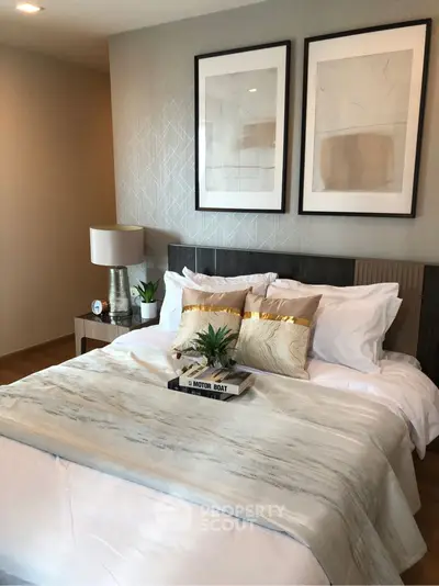 Elegant bedroom with modern decor and stylish artwork above the bed.
