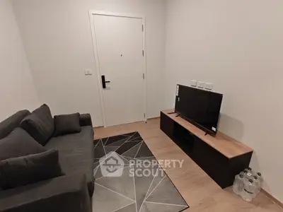 Cozy living room with modern sofa and TV setup, perfect for relaxation.