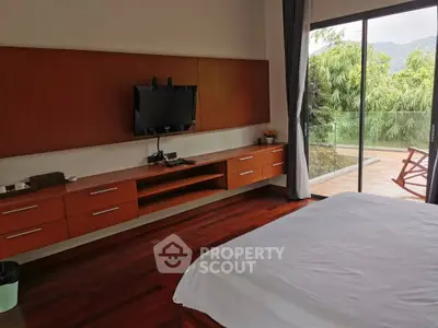 Luxurious bedroom with modern TV setup and stunning balcony view