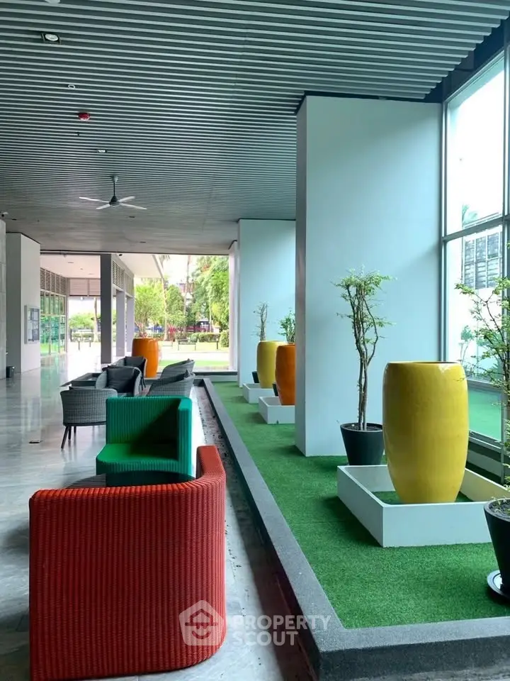 Modern building entrance with colorful seating and greenery